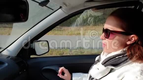 美丽的生活方式女人坐在车里视频的预览图