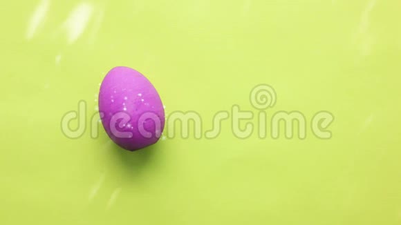 粉红色的复活节彩蛋在浅绿色的背景下阳光灿烂视频的预览图