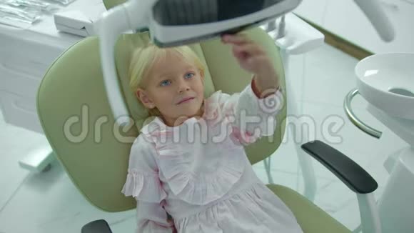 女孩坐在牙科椅上关掉灯视频的预览图