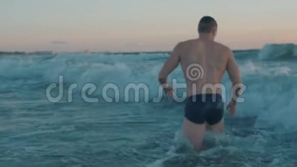 穿黑色内衣的肌肉男在日落时游泳视频的预览图