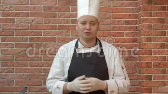 微笑的厨师站在厨房里和摄像机谈论他要准备的菜视频的预览图