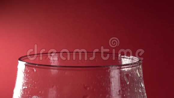 红色背景下的慢动作特写镜头倒入玻璃视频的预览图