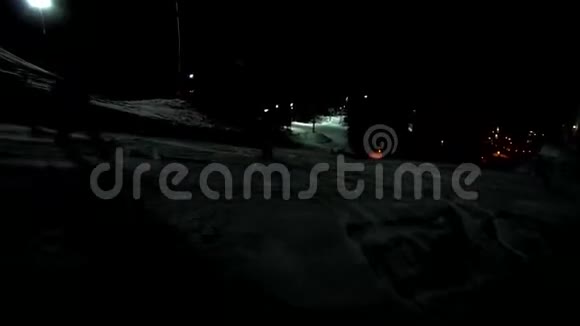 黑暗的夜间滑雪道与滑雪者和滑雪板滑雪者正从黑暗的一面骑到光明骑马视频的预览图