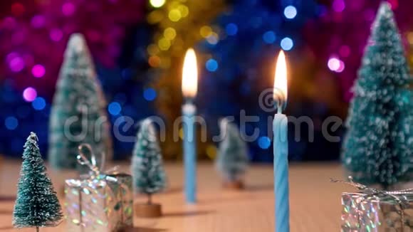 蜡烛在礼物和圣诞树中慢慢燃烧视频的预览图