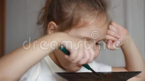 小女孩用勺子吃汤小孩吃美味的午餐视频的预览图