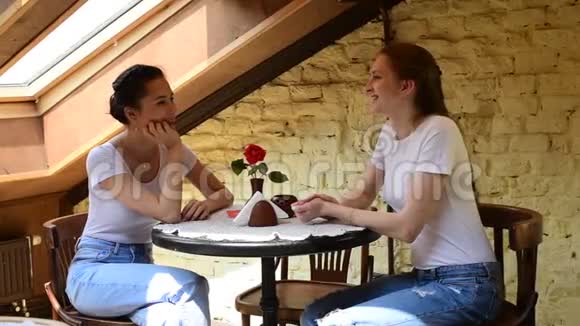 两个漂亮的女孩在咖啡馆里聊天日光灯视频的预览图