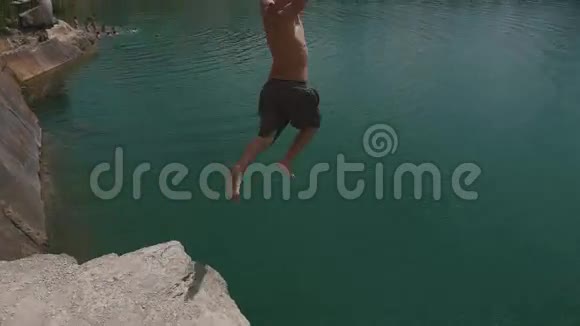 金发男人从悬崖上跳进水里夏日欢乐生活视频的预览图