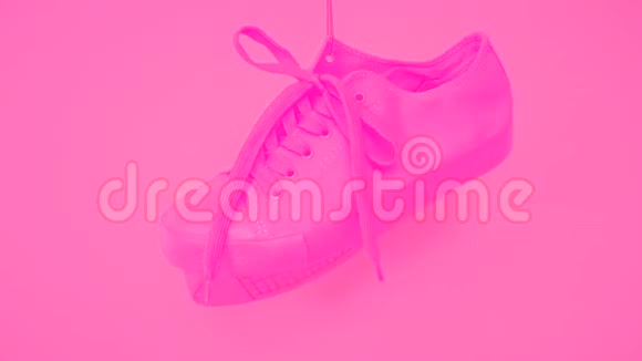 粉色女鞋的配对挂在粉色背景上明亮的玫瑰女的列车员在绳上闲逛时髦的高跷视频的预览图