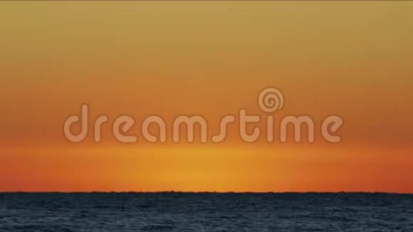 太阳从海面升起海滩上令人惊叹的红色日出橙色的日出和波浪黄色炎热的天空覆盖着视频的预览图