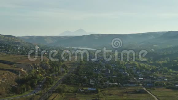 村庄在山上铁路电力线路鸟瞰视频的预览图