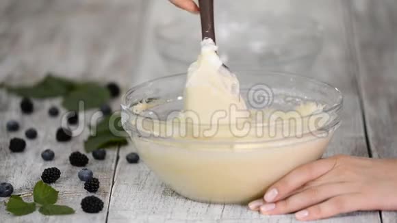 女人的手把海绵蛋糕的原料混合在玻璃碗里视频的预览图