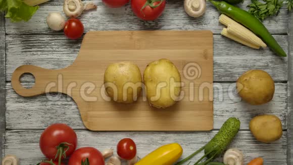 两个土豆的水果躺在一个切割板上双手同时抓土豆视频的预览图