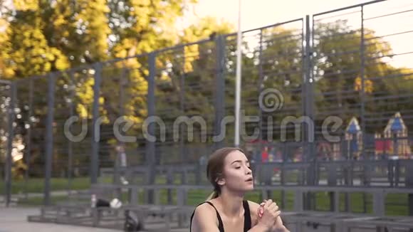 女健身队蹲在绿色公园的运动场上进行体育锻炼视频的预览图