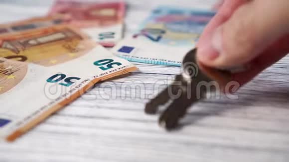 公寓或房子的钥匙手放在一张带着欧元钞票的白色木桌上视频的预览图