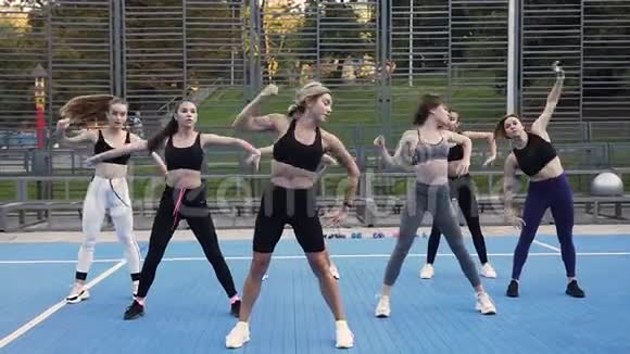 在公园运动场上的健身课上一群年轻有魅力的女人向左向右倾斜视频的预览图