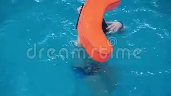 一个胖男孩带着浮子在游泳池里游泳视频的预览图