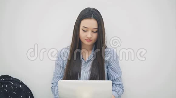 可爱但又疲惫的亚洲女孩长发盘膝手提电脑按摩太阳穴有些困难视频的预览图