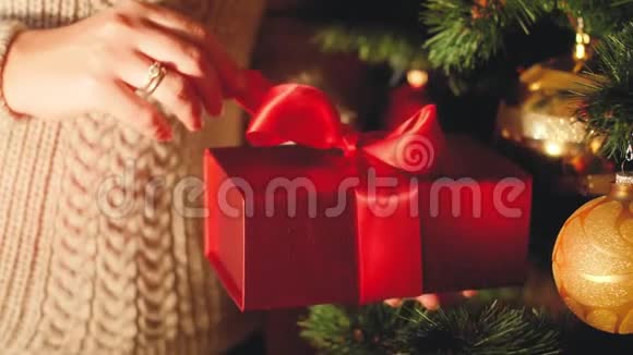 特写4k视频年轻女子拉红丝带和解开盒子与圣诞礼物视频的预览图