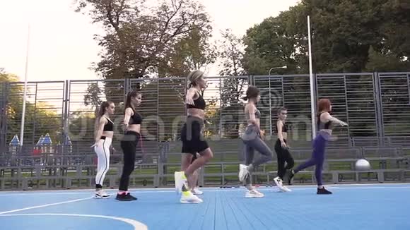 一群有吸引力的苗条妇女单腿站立在公园的健身训练中保持平衡视频的预览图