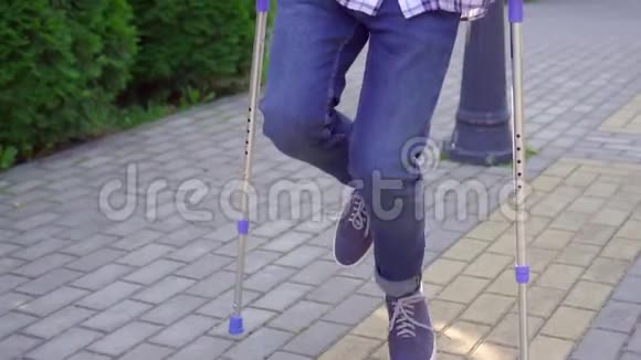 拄着拐杖断腿的亚洲年轻人在公园散步视频的预览图
