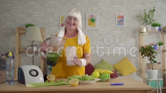 积极健身奶奶在搅拌机里准备了绿色冰沙运动饮食视频的预览图