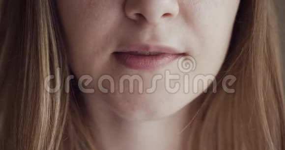 女孩咬着嘴唇用美丽柔软的嘴唇微笑视频的预览图