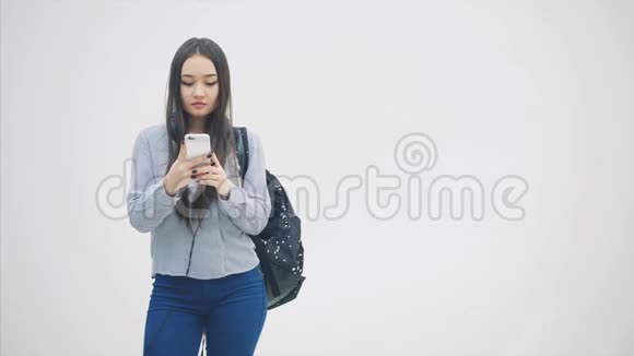 迷人的少年高中生女孩在电话里交谈微笑着学校背包肩并肩视频的预览图