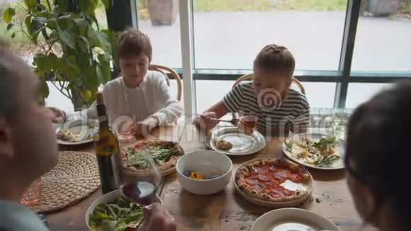 上景男孩从盘子里拿食物女孩吃披萨视频的预览图
