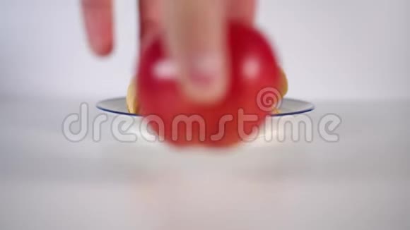 一只手把熟透的红苹果放在白桌上的盘子里的薯片前视频的预览图