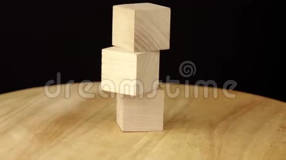 3个木立方体在木平台上旋转360度视频的预览图
