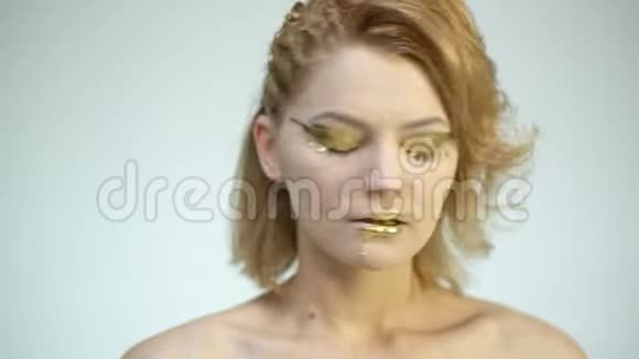 金色的颜料从嘴唇滴下性感的嘴唇滴下唇膏金色的液体滴在美丽的模特女孩嘴上视频的预览图