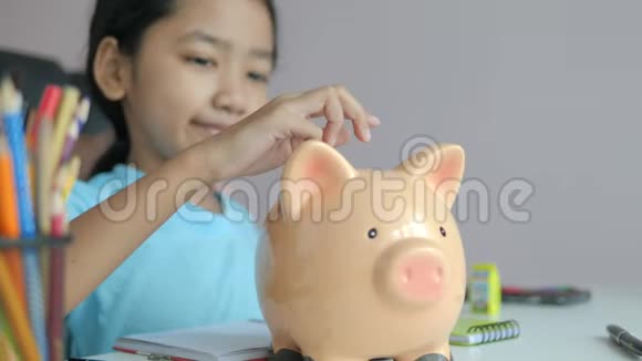 母亲和小亚洲女孩把硬币放进储蓄罐比喻为更好的未来省钱选择重点浅深视频的预览图