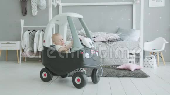可爱的婴儿在家中的婴儿车里玩耍视频的预览图