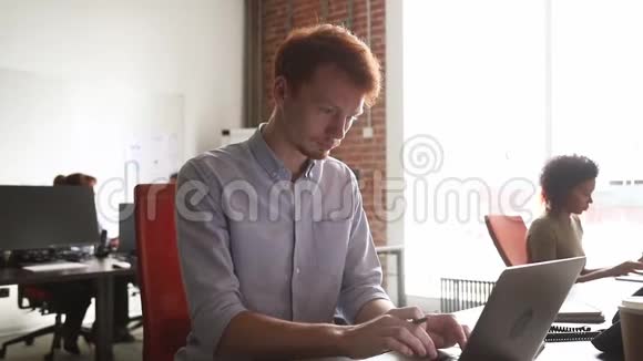 年轻男性员工完成计算机工作后对结果感到满意视频的预览图