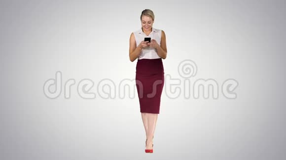 成功的女性雇主在她的手机上键入短信而走在梯度背景视频的预览图