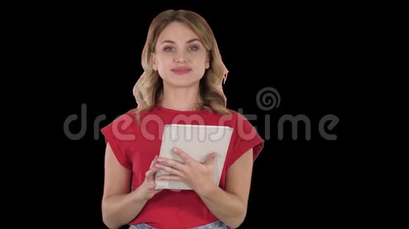 主持人女士穿着红色T恤手里拿着平板电脑翻页对着镜头说话阿尔法频道视频的预览图