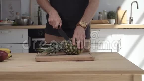厨师在木板上切菠萝男人厨师手在厨房里切菠萝新鲜菠萝楔子视频的预览图