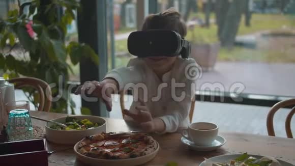 小男孩在咖啡馆里玩虚拟现实眼镜视频的预览图