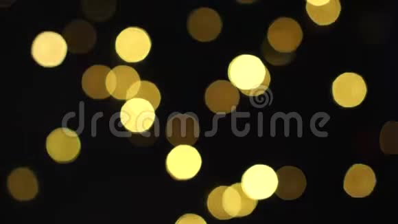 一个圣诞花环的黄色灯光不再聚焦在黑色的背景眨眼上视频的预览图