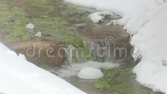 一条河的小瀑布河岸上有海藻和雪视频的预览图