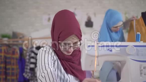 年轻的穆斯林女时装设计师在国家头巾缝制缝纫机上视频的预览图
