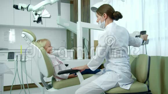 医生调节小病人坐的椅子视频的预览图