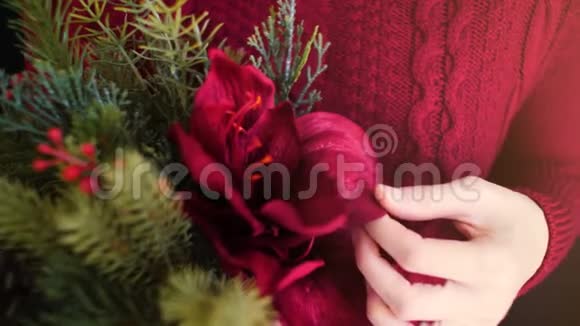 女性穿红色毛衣手捧圣诞花束视频的预览图
