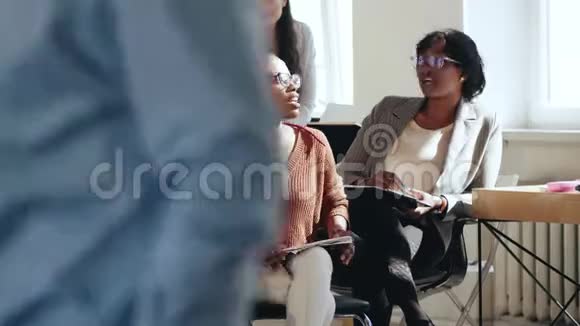 快乐轻松的女性商业公司员工在现代阁楼办公室休息时聊天健康多样的工作场所视频的预览图