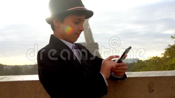 男孩在埃菲尔铁塔的背景上写短信视频的预览图