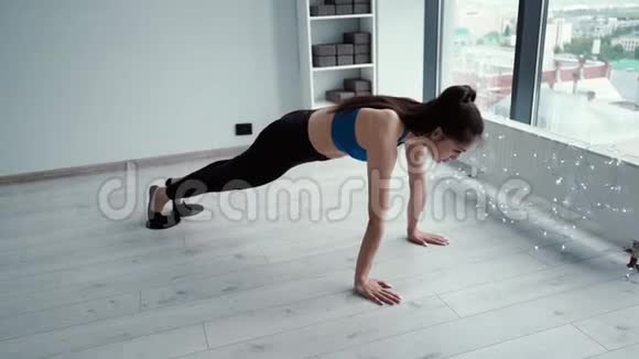 女健身教练用滑翔盘在健身房地板上伸展腿视频的预览图