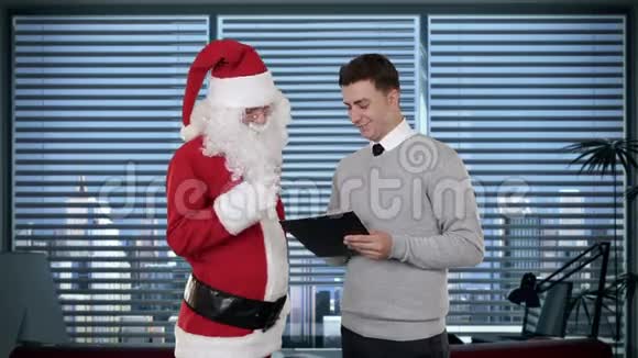 现代办公室里的圣诞老人和年轻商人股票录像视频的预览图
