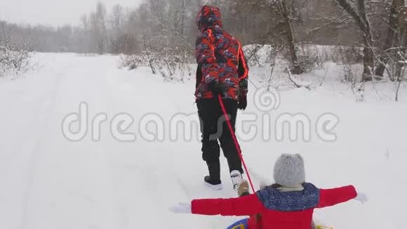 快乐的爸爸是幸运的在一个孩子雪白的道路上雪橇圣诞节假期和旅行为成年人提供一个有趣的游戏视频的预览图