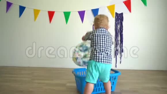 小男孩在家玩洗衣盒和球万向节运动视频的预览图