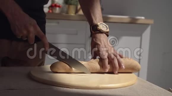 厨师在木板上切面包男厨师在木切割板上切片面包的特写切面包视频的预览图